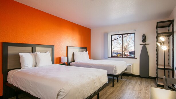 A hotel room with two beds, a window with a view, a shelf with lights, and a heater. - Siegel Select Albuquerque (Albuquerque)