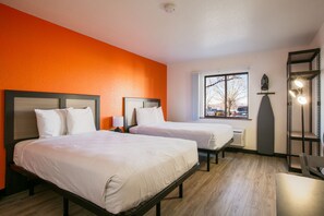 A hotel room with two beds, a window with a view, a shelf with lights, and a heater. - Siegel Select Albuquerque (Albuquerque)