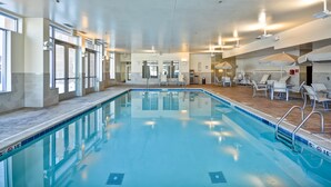 An indoor swimming pool with clear water, surrounded by lounge chairs and sun umbrellas. - HYATT house Chicago/Naperville/Warrenville (Warrenville)
