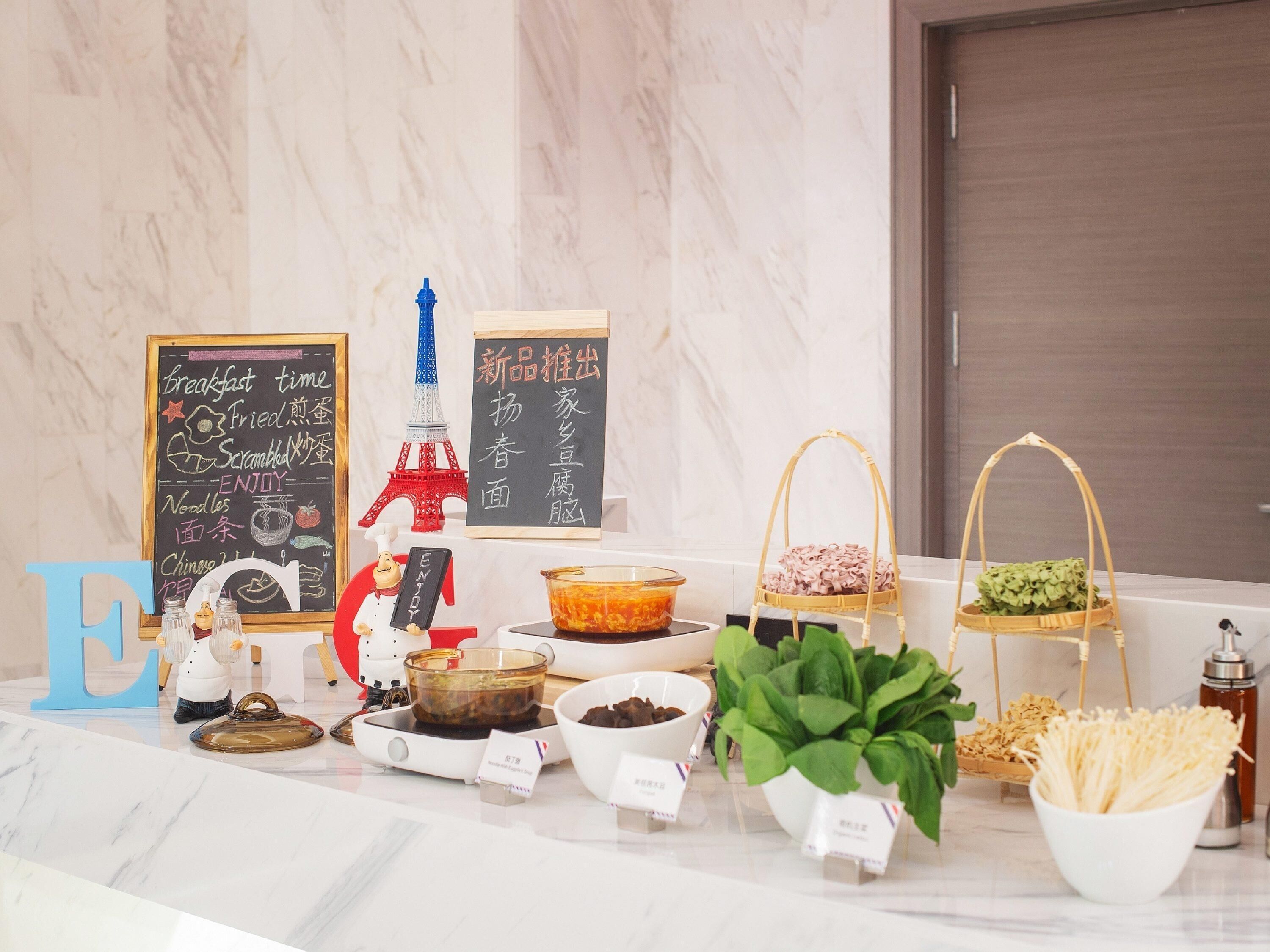 A breakfast buffet setup with various food items and a decorative Eiffel Tower model.