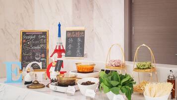 A breakfast buffet setup with various food items and a decorative Eiffel Tower model.