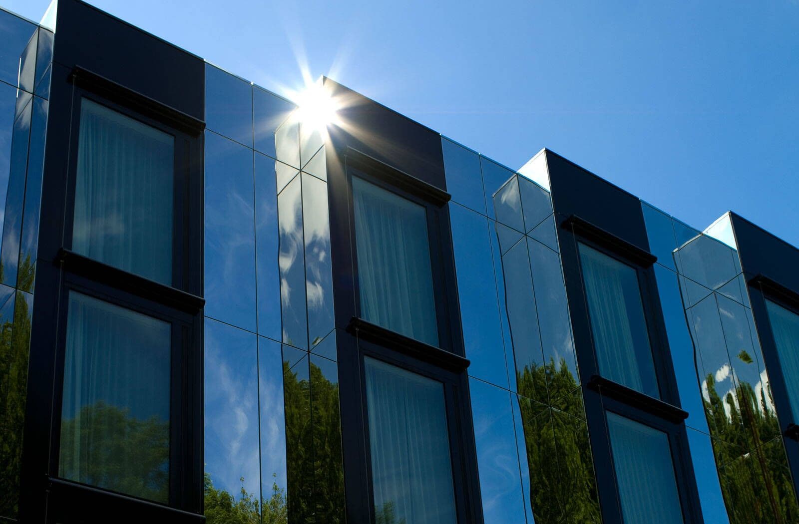 A modern building with reflective glass windows and a clear sky.