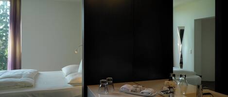 Una habitación de hotel con cama, baño con lavamanos y espejo.