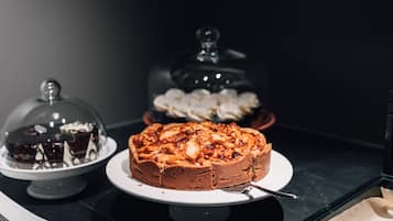 A dessert display with cakes and pastries on a marble countertop.