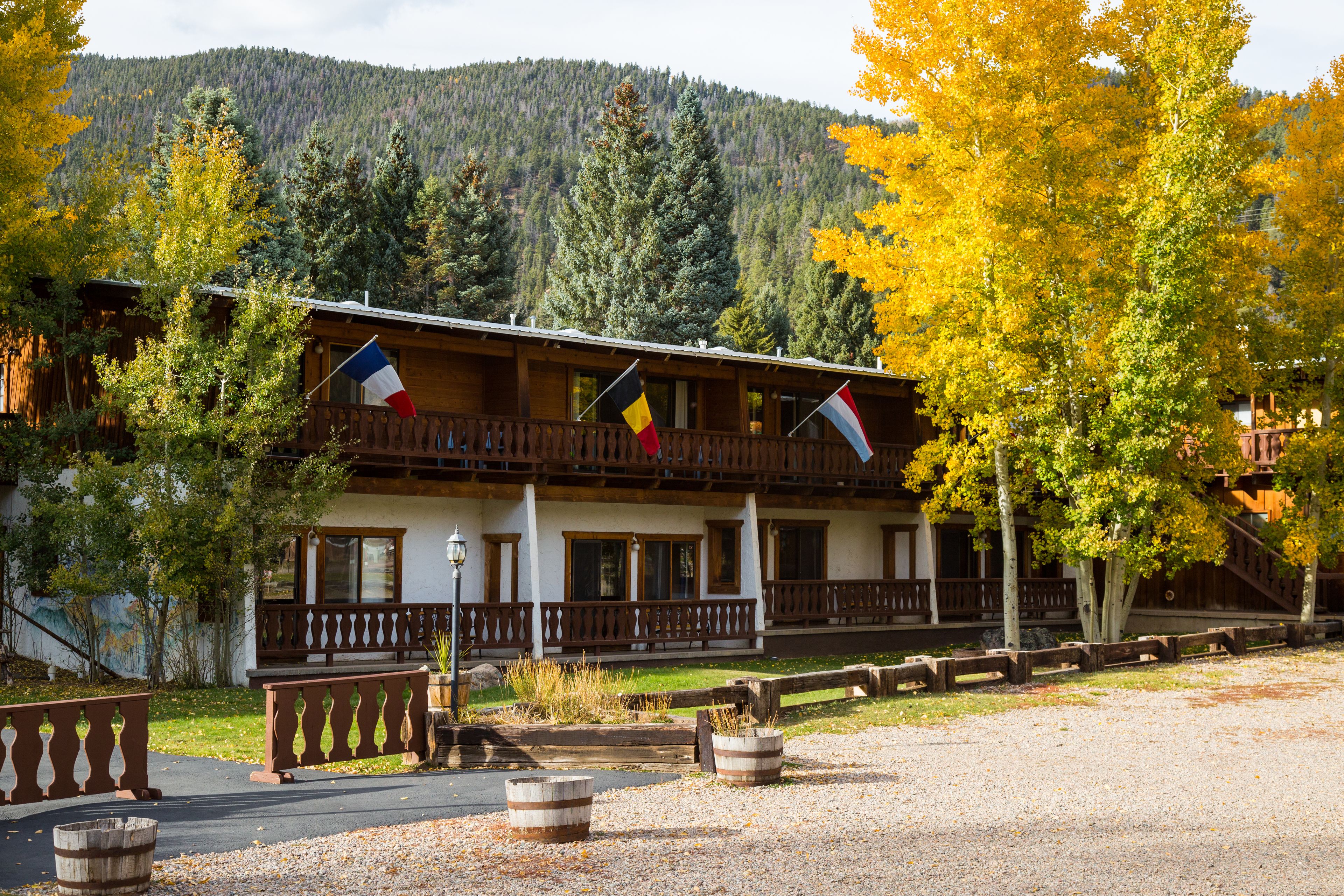 A lodge with a balcony, wooden railings, and flags.