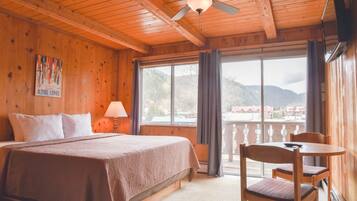 Quarto de madeira com cama, mesa e cadeiras.