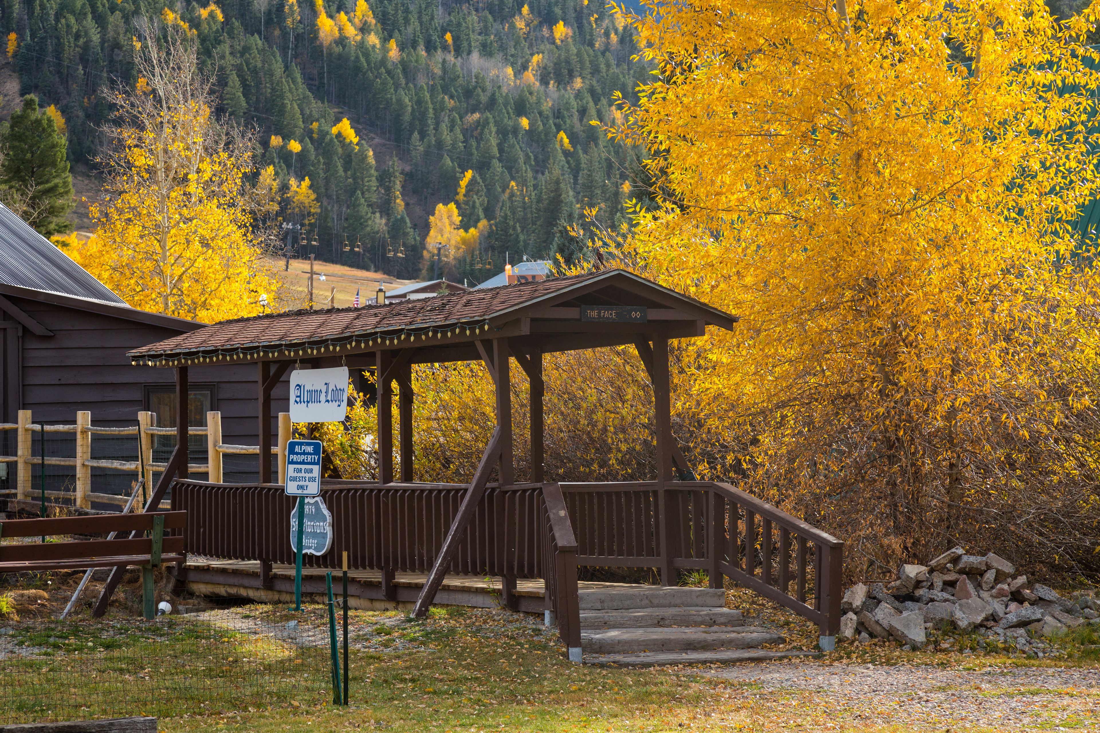 A wooden lodge with a covered porch and a sign indicating it is a ski resort.