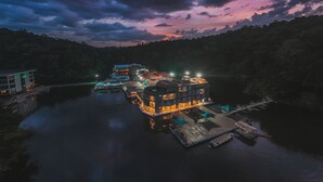 Un hotel frente al agua con varias construcciones, un muelle y un puente.