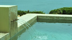 Une piscine à l’eau claire, avec vue sur la mer.