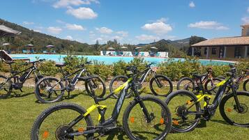 A poolside area with multiple bicycles parked on the grass.
