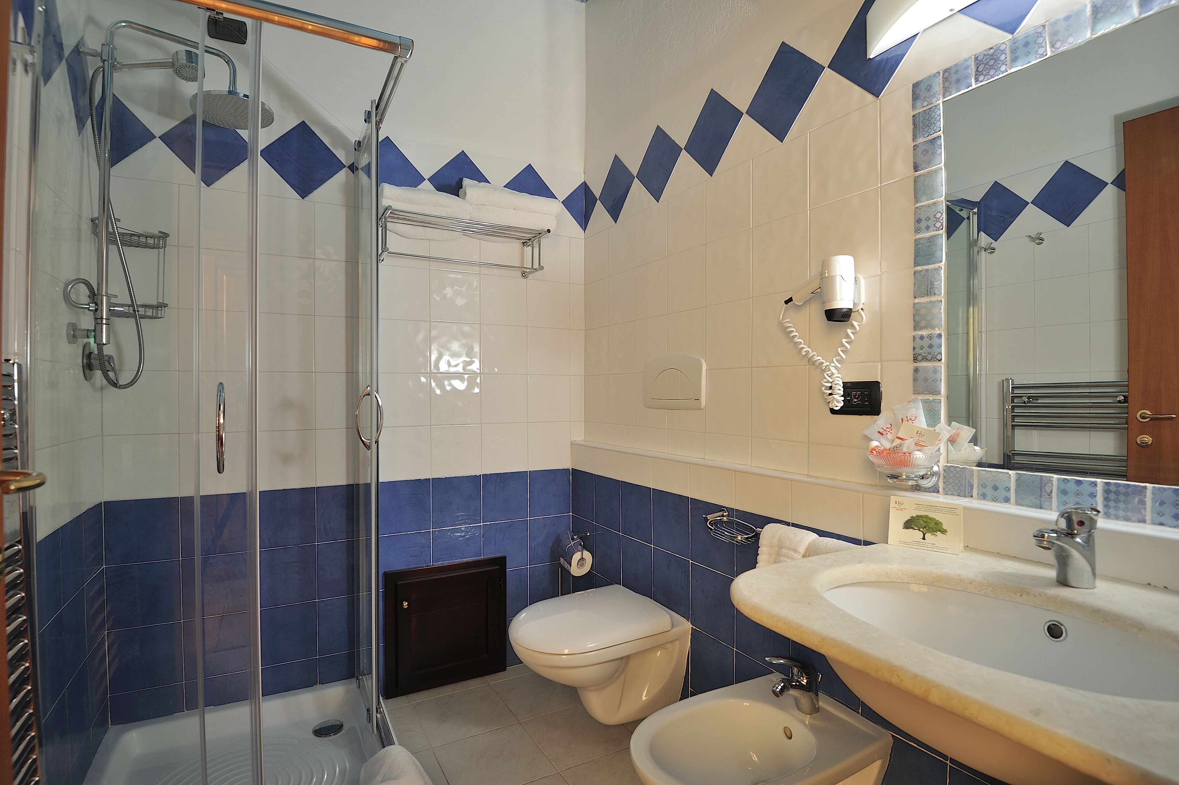 Une salle de bain avec une douche à parois de verre, des toilettes et un lavabo avec un miroir.