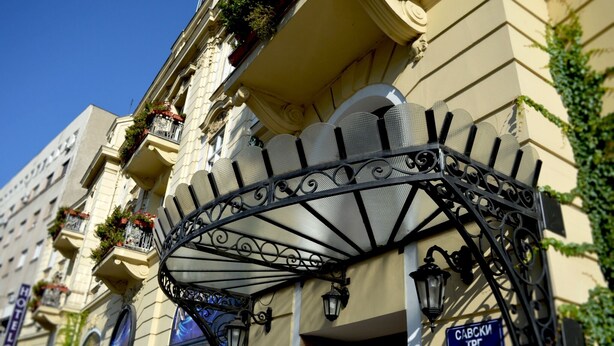 A building with a balcony with wrought iron railings and a blue sign indicating the address. - Belgrade City Hotel (Belgrade)