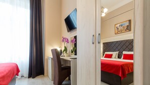 A hotel room with a bed, a desk, a chair, a TV, and a window with curtains. - Belgrade City Hotel (Belgrade)