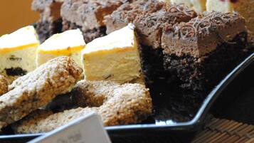 A display of various cakes and pastries on a tray.