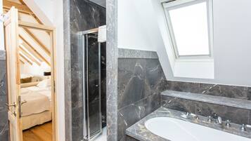 Ein modernes Badezimmer mit Dusche, einer großen Badewanne und einem Oberlicht.