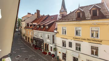 A street view of a historic town with buildings featuring traditional architecture, including a hotel with a sign reading "Hotel".