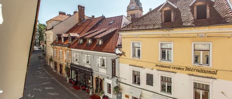 A street view of a historic town with buildings featuring traditional architecture, including a hotel with a sign reading "Hotel".