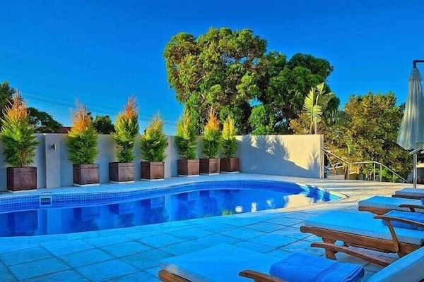 Piscine extérieure, parasols de plage, chaises longues