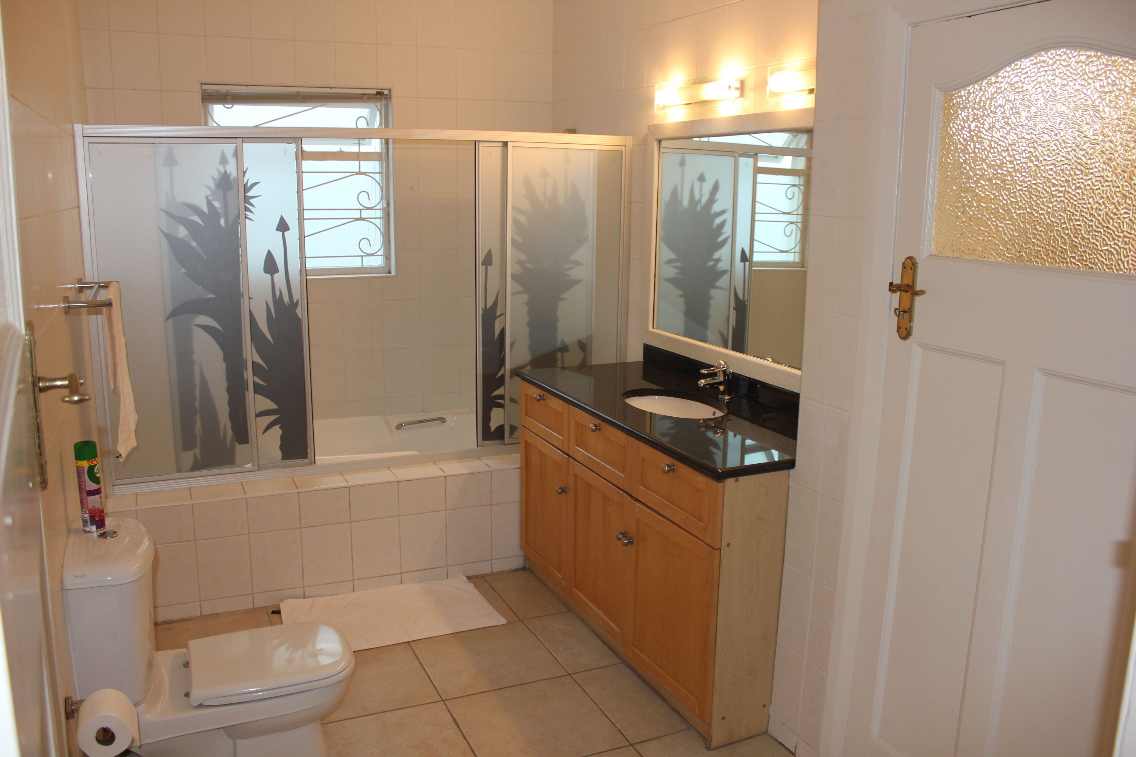 A bathroom with a toilet, sink, vanity, and bathtub.