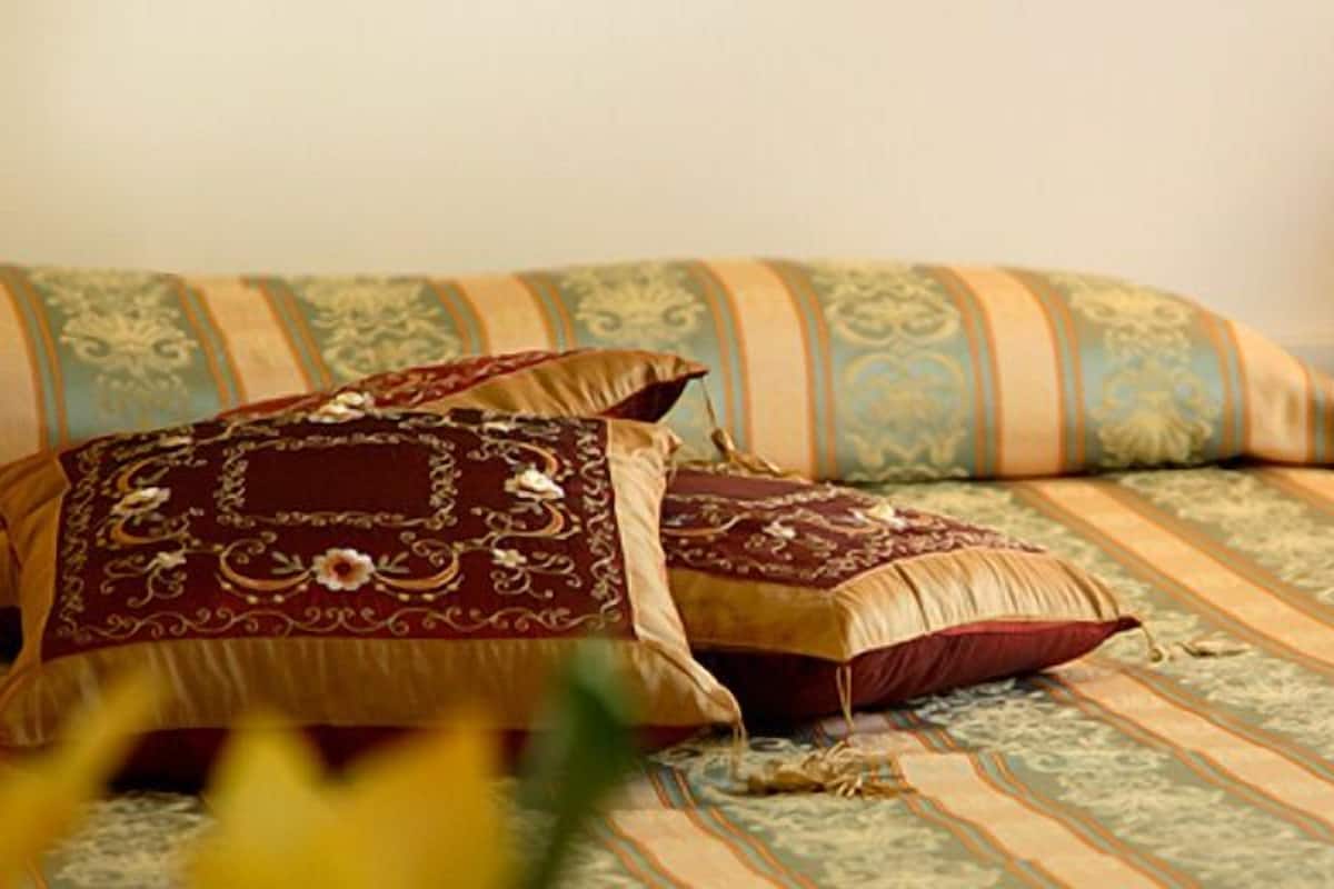 Un lit bien fait, avec une literie à motifs et un coussin décoratif.
