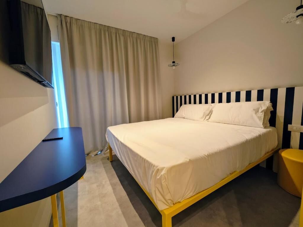 Une chambre à coucher avec un lit, un bureau, une chaise et un téléviseur.