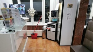 A modern kitchen with a wooden floor, a red mop, and a coffee machine. - Flipper Hotel Amsterdam (Amsterdam)