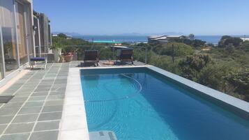 Alberca al aire libre y camastros