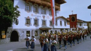 Un edificio tradicional con un balcón y una torre de reloj.