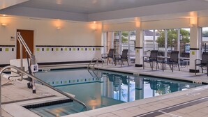 A swimming pool with a tiled deck, chairs, and a staircase leading to an upper level. - Fairfield Inn & Suites by Marriott Pelham (Pelham)