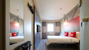 A hotel room with two beds, a TV, a mirror, and a window with curtains. - ibis Nanjing Zhonghua (Nanjing)
