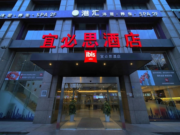 The exterior of a hotel with a prominent sign for "Ibis Hotels".