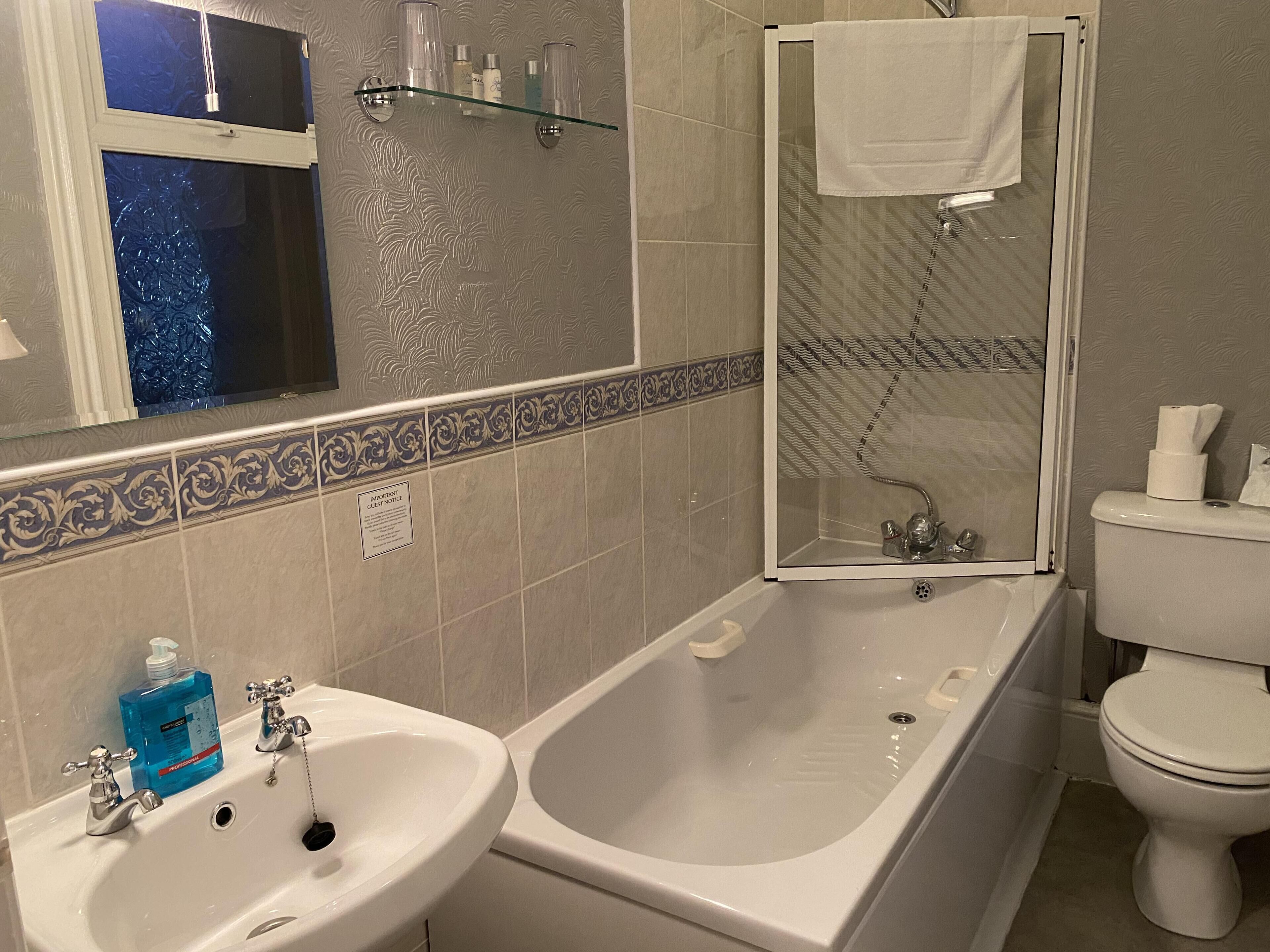 A bathroom with a bathtub, a sink, a toilet, and a glass shower enclosure.