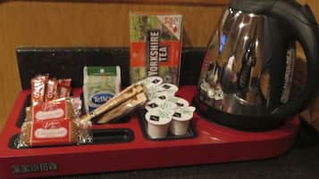 A red tray with Yorkshire Tea, Tetley tea bags, and a kettle on a countertop.