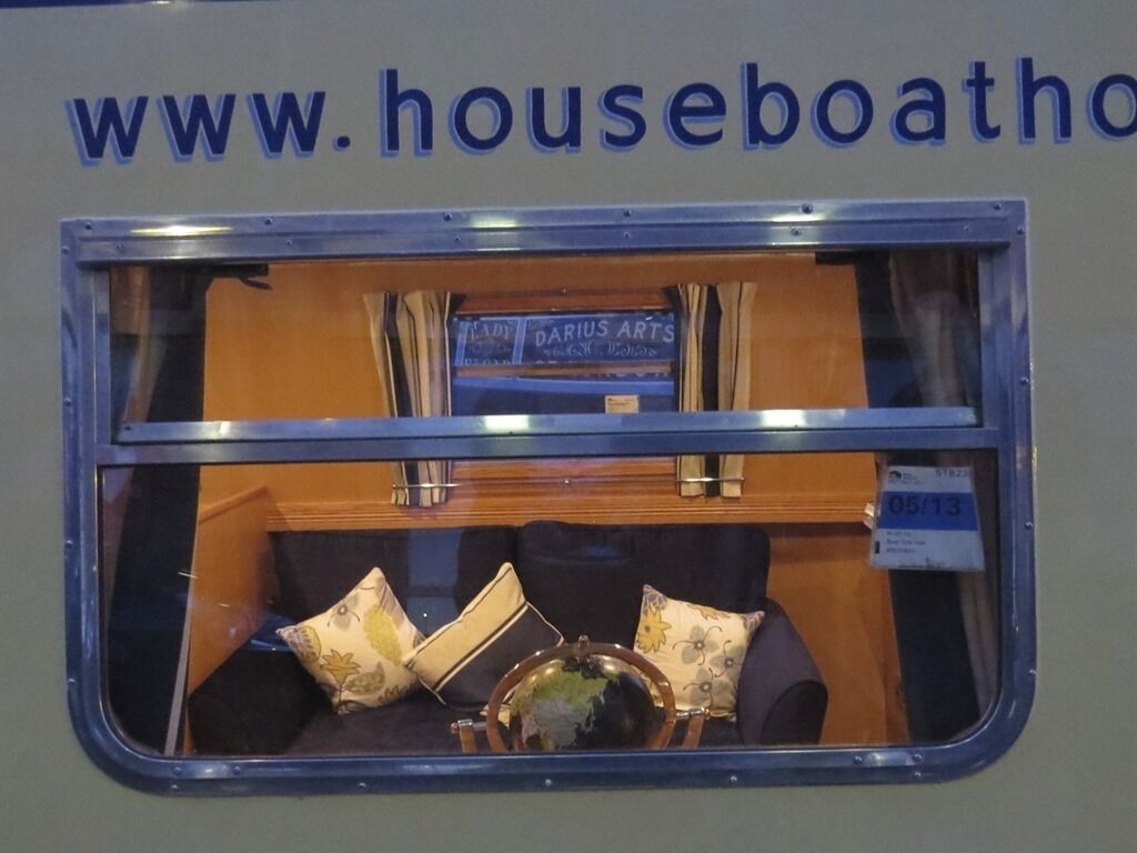 Una vetrina con un cartello che recita "www.houseboathq" e un libro intitolato "DARIUS ARTS".