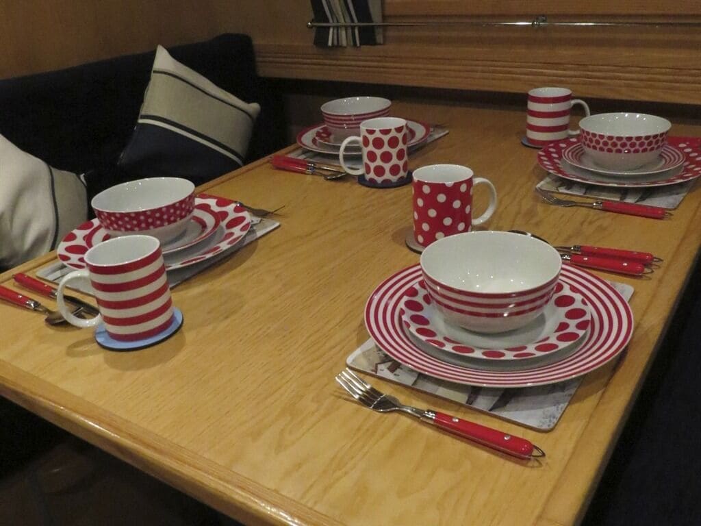 A dining table set with red and white striped tableware and utensils.