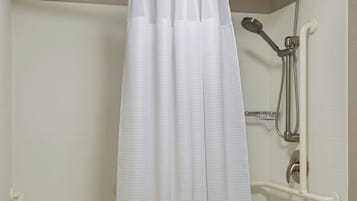 A modern bathroom with a bathtub, shower, and a white shower curtain.