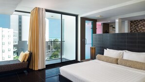 A modern hotel room with a large bed, a sofa, and a balcony with a view of the city. - Tsix5 Hotel (Pattaya)