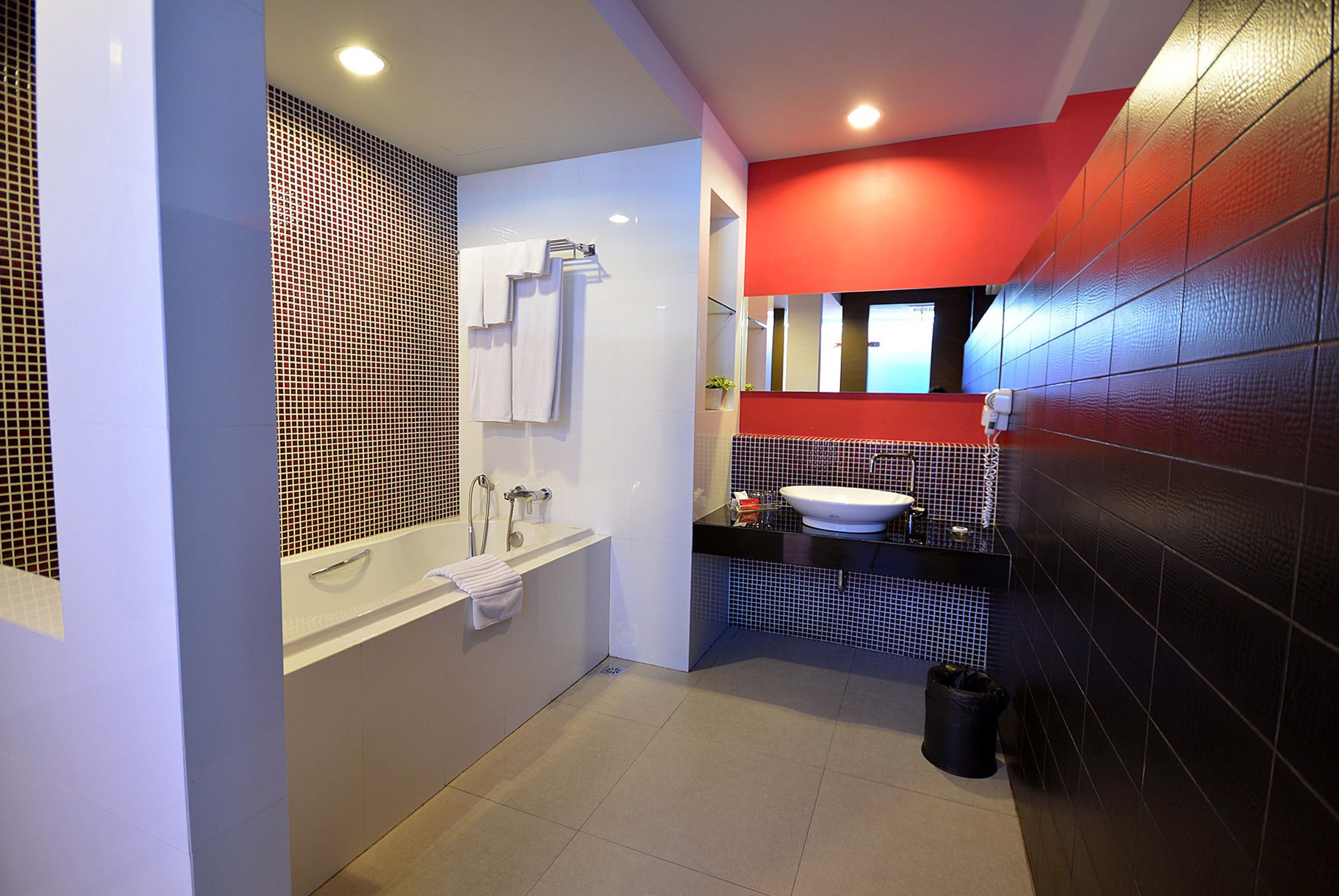 A modern bathroom with a bathtub, a sink, and a mirror.