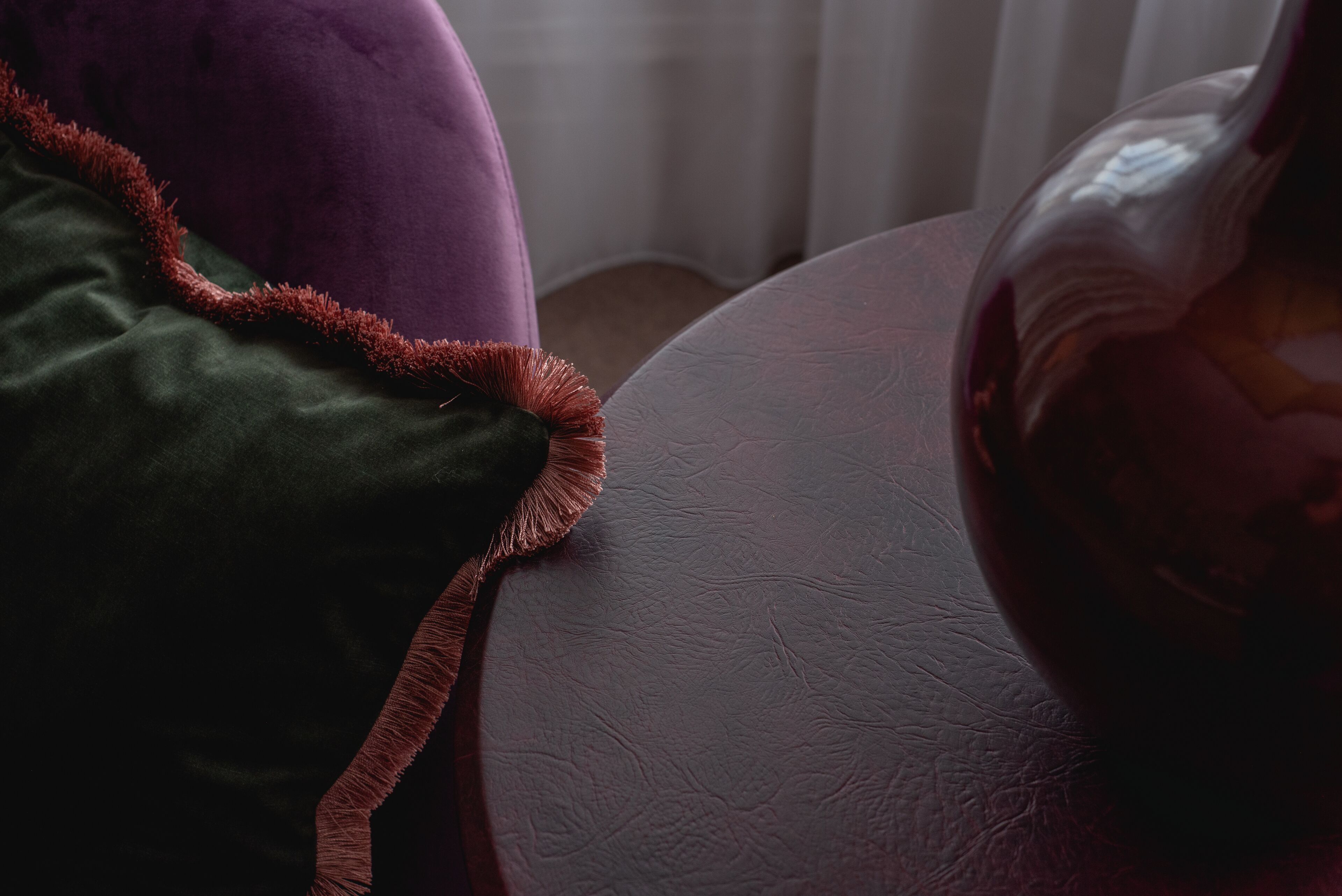 A close-up of a purple and green upholstered chair with a textured surface.