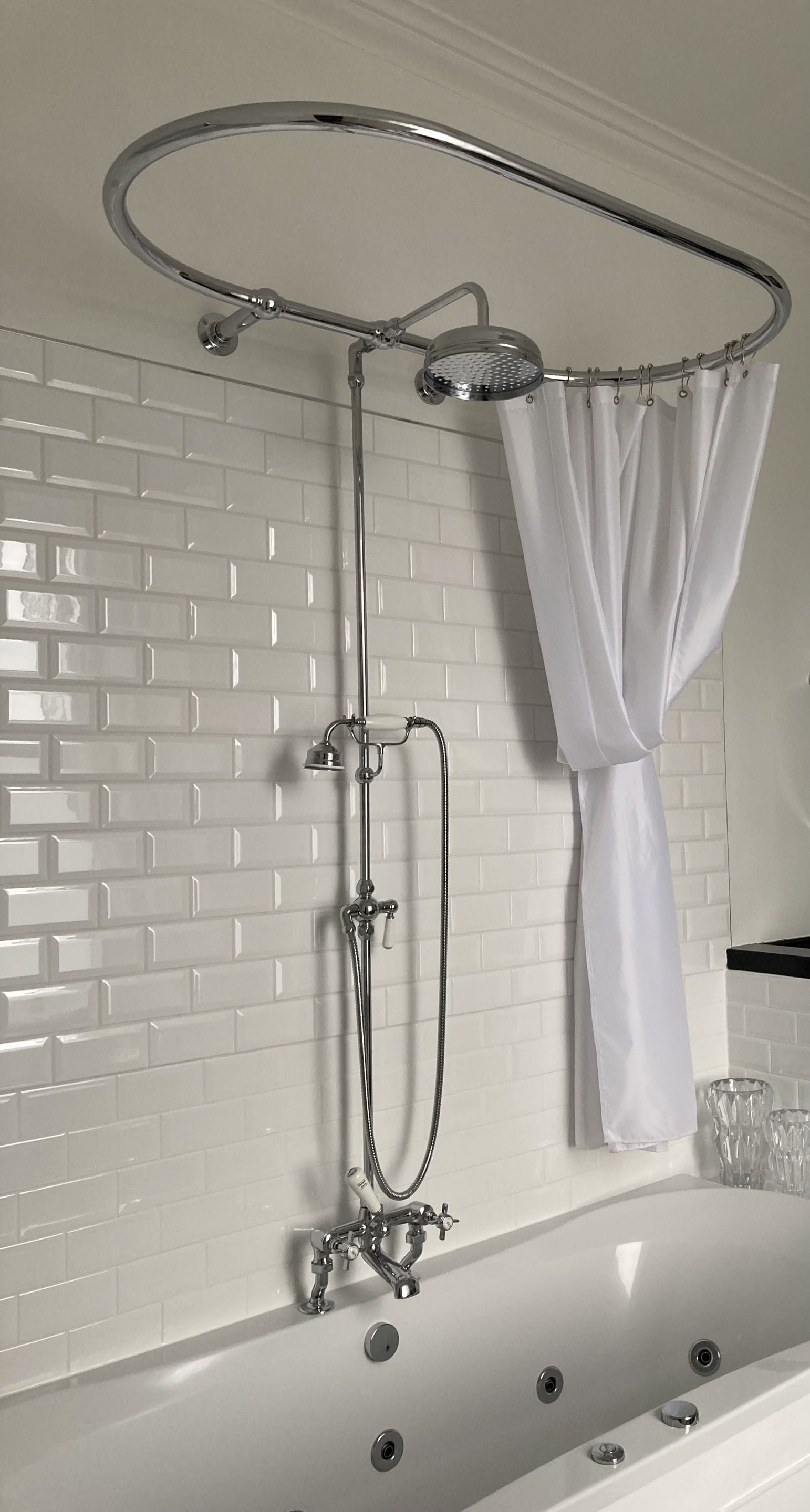 A bathroom with a bathtub, shower, and a curtain.