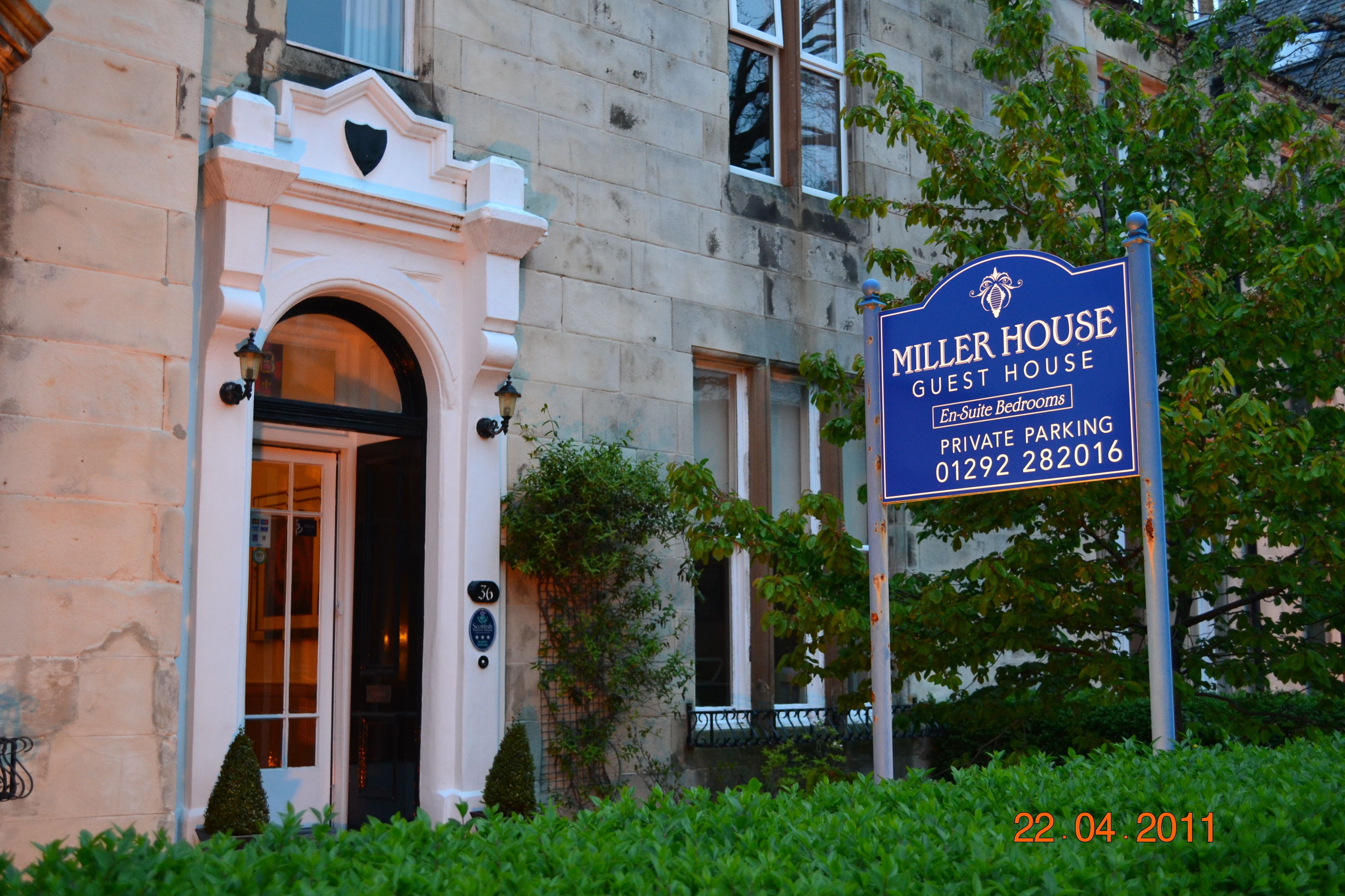 A guest house with a sign indicating en-suite bedrooms and private parking.