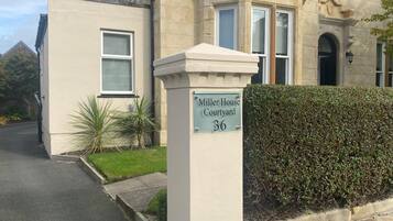 A building with a sign reading 'Miller House Courtyard 36' indicating a property number.