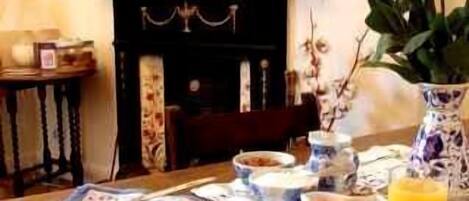 A dining table set with plates, bowls, cutlery, and a glass of orange juice.