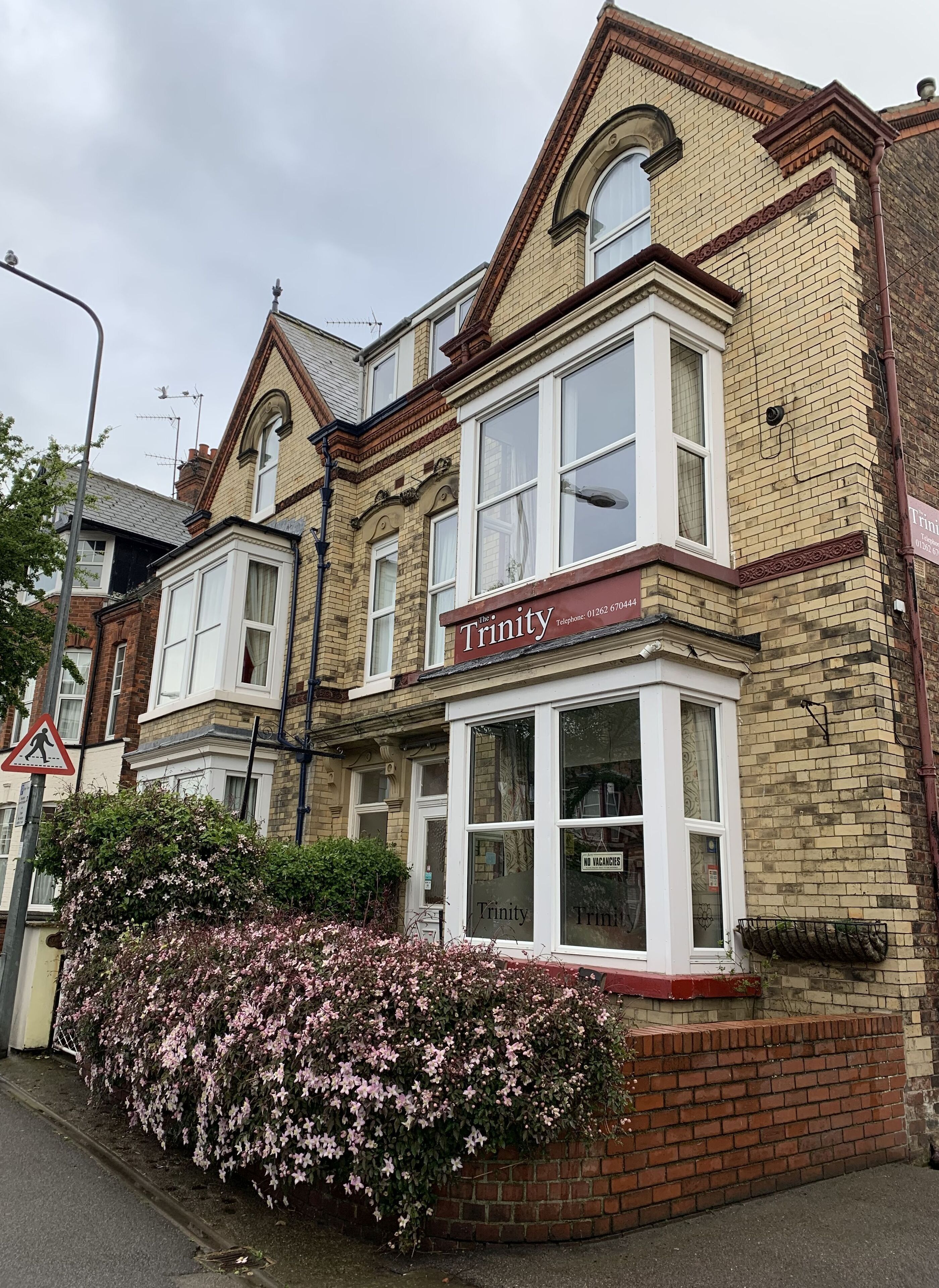 A two-story building with a prominent 'Trinity' sign at the ground floor entrance.