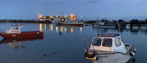 A marina with several boats docked, including a red boat named AMIGO and a white boat named ARTENIS.
