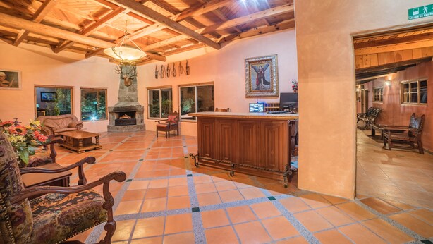 A spacious lobby with a fireplace, wooden furniture, and a stone fireplace.
