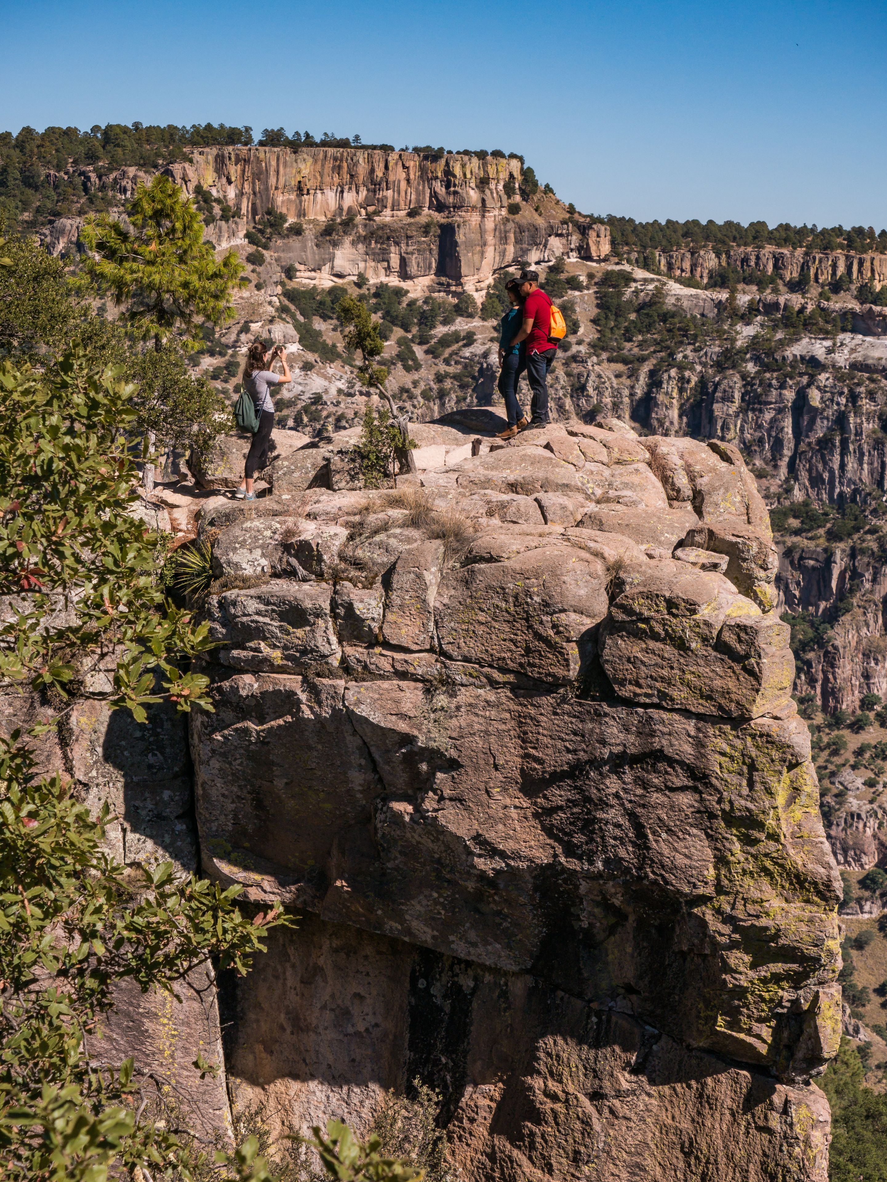 A rocky cliff with hikers.