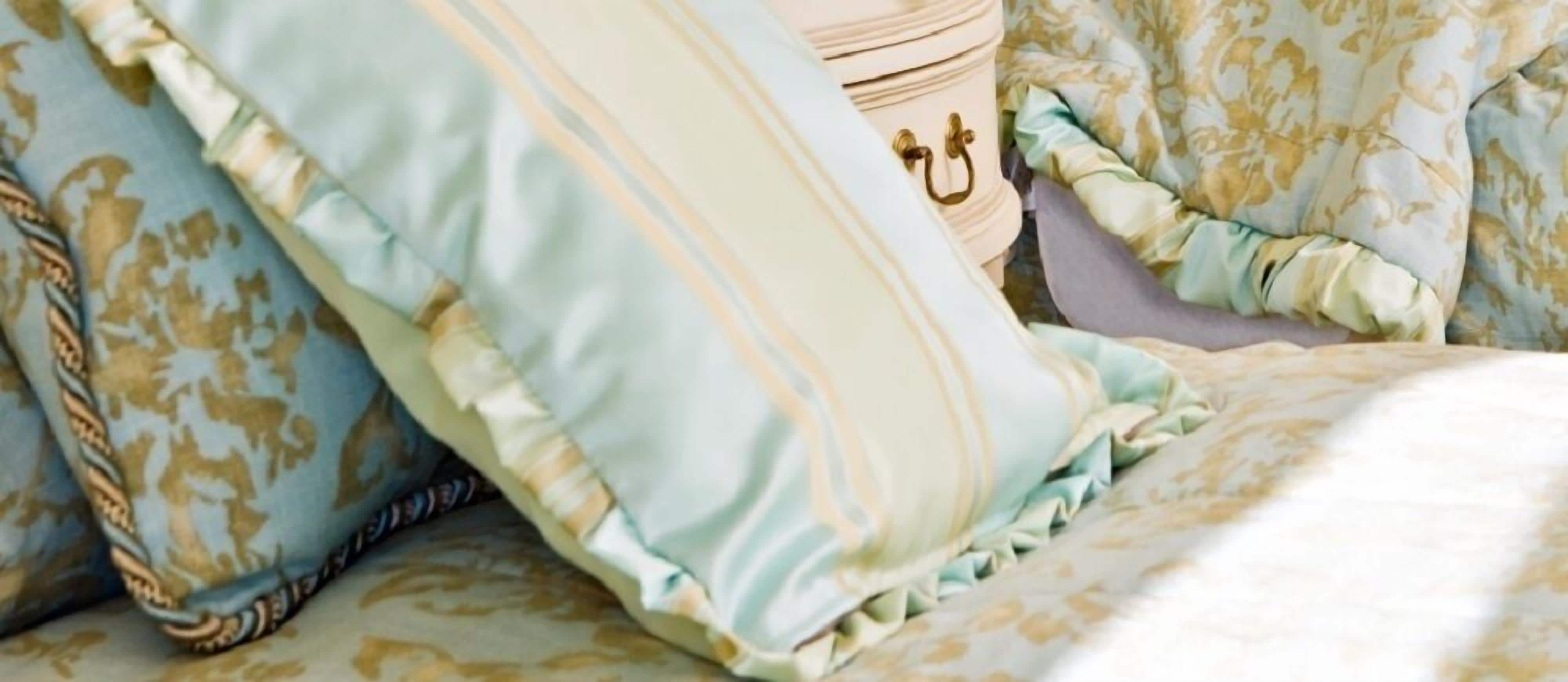 A bed with patterned bedding and a decorative pillow.