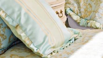 A bed with patterned bedding and a decorative pillow.