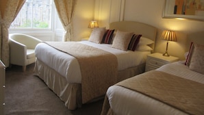 A hotel room with two beds, a chair, a nightstand, and a lamp. - Sonas Guesthouse (Edinburgh)